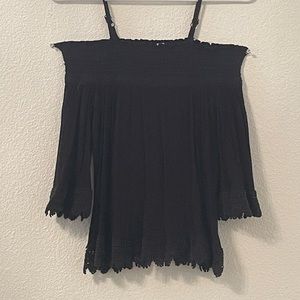 This is an off the shoulder black tank top with lace at the ends